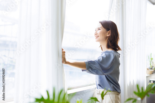 カーテンを開ける女性