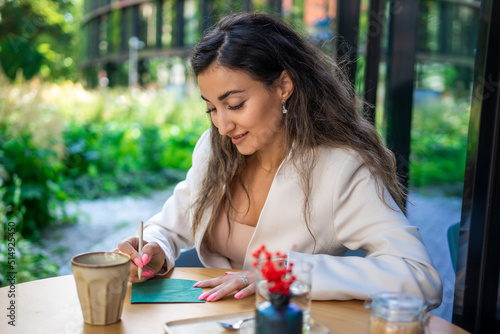 Canvas Print Young business woman drawing ideas on a napkin in street cafe of Prague