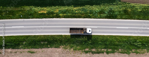 Top view aerial of semi-end dump truck with empty trailer on the road photo