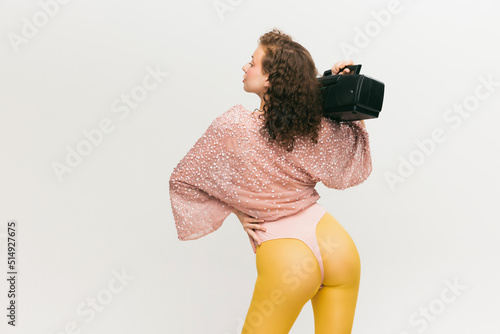Closeup. Back view of young fashionable girl in avant-garde style outfit over white background. Vivid style, beauty, queer, freak, fashion concept.