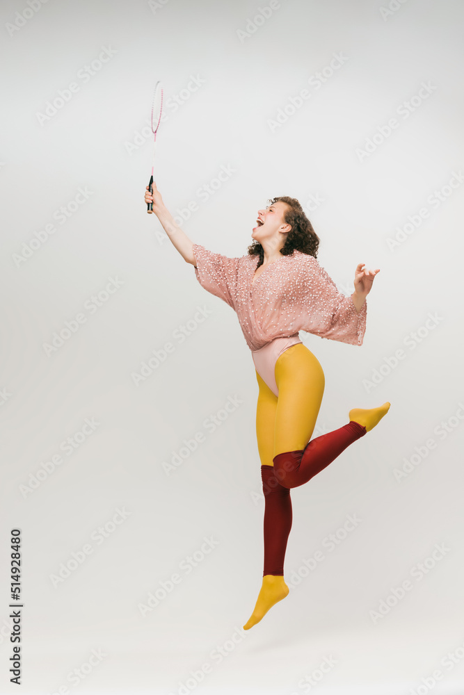 Fototapeta premium Portrait of young beautiful astonished girl in avant-garde style over white background. Vivid style, beauty, queer, freak, fashion concept.