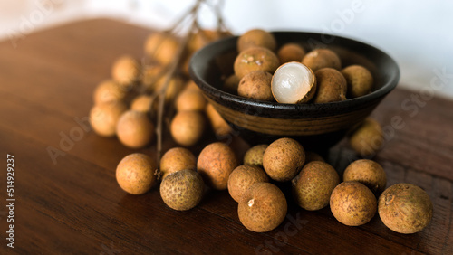 fresh longans in plate on wooden background