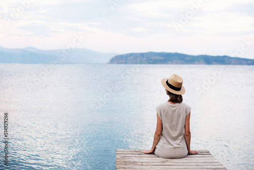 Young woman looking at the sea, Pretty girl looking at sunset on vacation, Relaxation, vacations, travel lifestyle, summer fun, enjoying life concept.