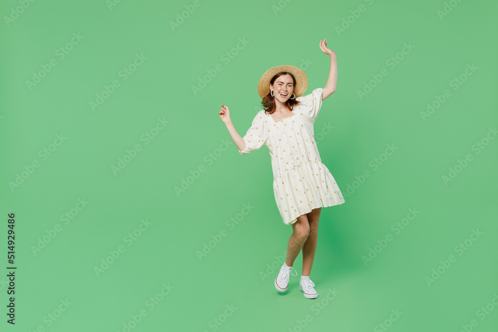 Full body young happy smiling fun cool woman she 20s wear white dress hat raise hands dance enjoy summer time isolated on plain pastel light green background studio portrait. People lifestyle concept Full body young happy smiling fun cool woman she 20s wear white dress hat raise hands dance enjoy summer time isolated on plain pastel light green background studio portrait. People lifestyle concept