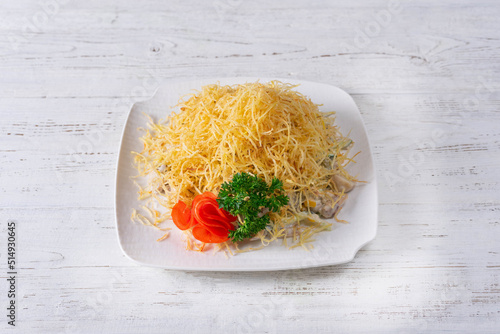 Mimosa is a festive layered salad. on a white wooden background