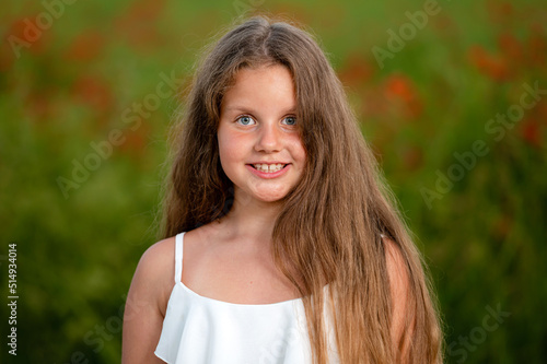 portrait of a girl on the background of a field of poppies in the evening sunlight, closeup