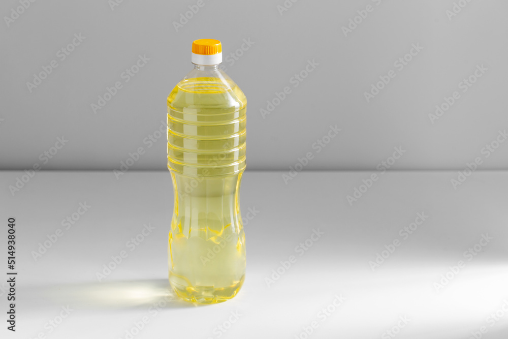 storage, food and culinary concept - close up of cooking rapeseed oil in plastic bottle on table - obrazy, fototapety, plakaty 