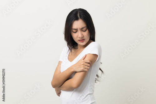 Asian women have skin problems She felt irritation on her skin. Skin infection itching red rash scratching with hands. She around 25 Wearing white shirt standing on isolate background © Chanakon