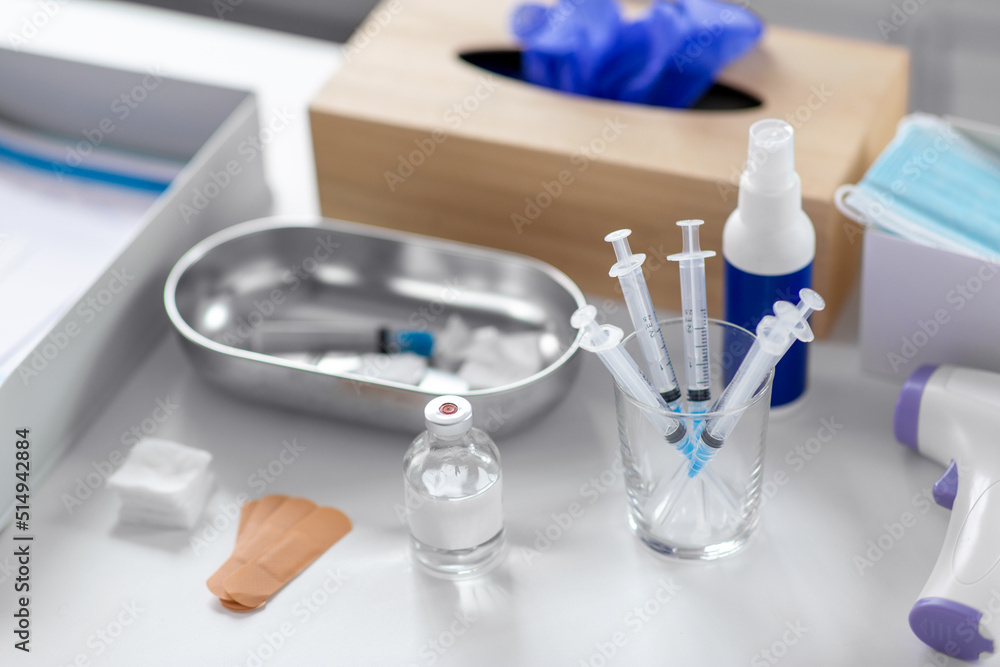 Fototapeta premium medicine and healthcare concept - close up of syringes, drug in jar and other stuff on table at hospital