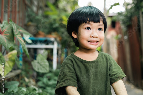 Happy moment of little child playing in home garden. Asian boy love and caring the environment. The smile of a kid with a beautiful nature. Ecology concept.