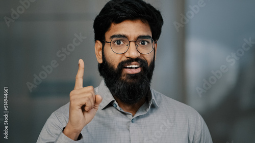 Close-up portrait arabian male pensive business man hold hand on chin concentrated think of solution issue deep in thoughts excited young eyeglasses guy raise finger come up with good idea find answer © Yuliia