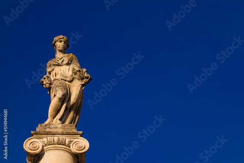 Abundantia  ancient roman goddess of abundance  wealth  money  prosperity  fortune  and success. A 15th century statue erected in the Pisa historical center  with blue sky and copy space 