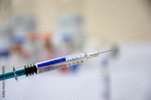 syringe with a drop of medicine on the needle close-up. injection, syringe with medicine close-up