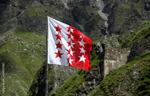 Obraz na plátně Swiss Canton Valais Flag, sight from mountain lake Dix, Valais, Switzerland, swiss alps the biggest dam in Europe