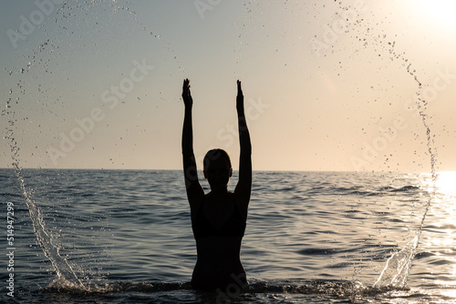 young girl having fun make splashes in shallow water