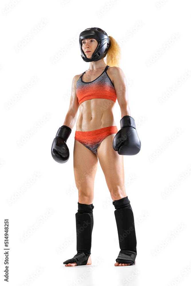 Sportive woman, female professional kickboxer in sports gloves and protective helmet posing isolated on white background. Sport, achievements concept