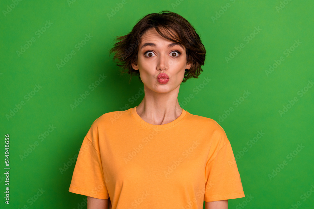 Fototapeta premium Photo of funky sweet young lady wear orange outfit sending you kiss isolated green color background