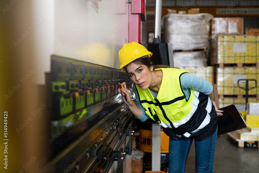 Portrait of female staff smiling with holding clipboard standing in warehouse with looking at camera, Industrial and industrial workers concept. Portrait of female staff smiling with holding clipboard standing in warehouse with looking at camera, Industrial and industrial workers concept.