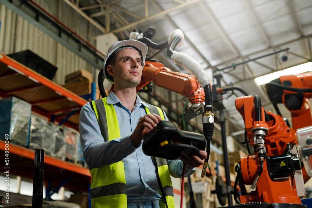 Male engineer checking and inspection control a robot arm machine welding steel in an industrial factory, Fast and highly secure. Male engineer checking and inspection control a robot arm machine welding steel in an industrial factory, Fast and highly secure.