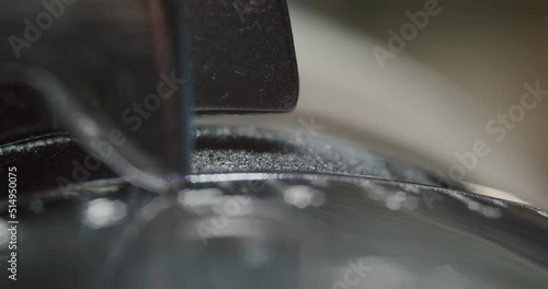 Close up view of tailor thinning leather piece with leather skiving machine passing for making shoes in workshop background, slow motion 4k photo