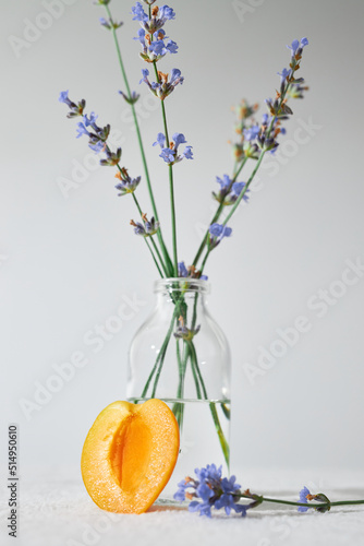 Bottle of essential oil with lavender flowers on white background.