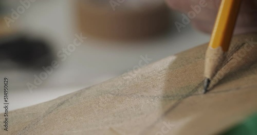 Close up view of tailor draws a sketch on a shoe blank with pencil in private leather craftshop making shoes in process in 4k resolution photo