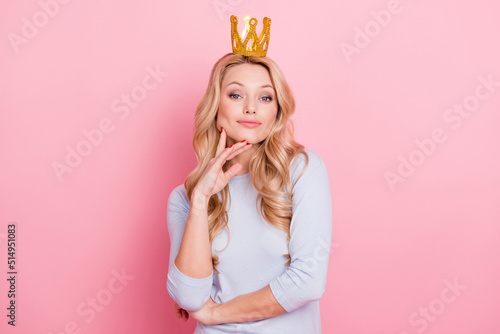 Portrait of nice lovely girl hand touch face look camera wear crown isolated on pink color background