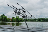 Spinning. Fishing with signaling devices on holder.  Feeder fishing with reel. Rod pod. Fishing rods for pike, perch, carp on pond. Angler with fishing technique. World Fisherman's Day, photo article.