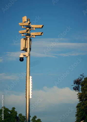 Several seurity cameras in the city with trees et blue sky