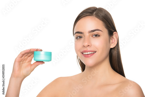 happy young girl presenting cream jar for face skin with copy space, moisturizing balsam.