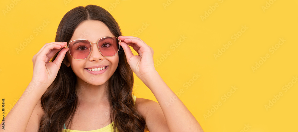 happy child in summer glasses has curly hair on yellow background, beach fashion. Child face, horizontal poster, teenager girl isolated portrait, banner with copy space. happy child in summer glasses has curly hair on yellow background, beach fashion. Child face, horizontal poster, teenager girl isolated portrait, banner with copy space.