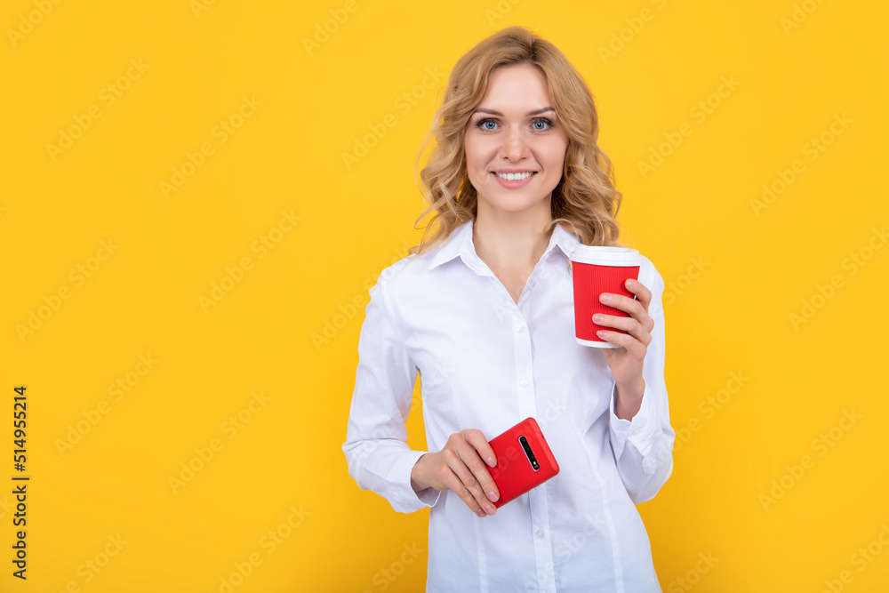 happy blonde woman with coffee cup and smartphone on yellow background happy blonde woman with coffee cup and smartphone on yellow background