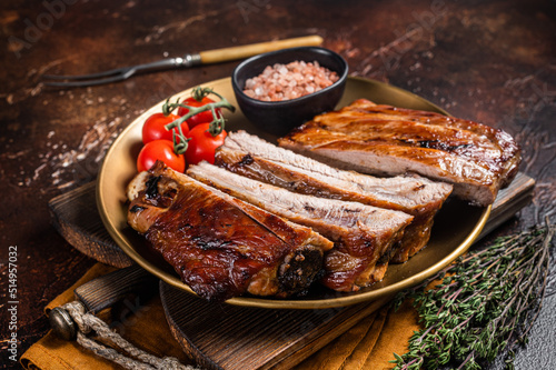 Chopped BBQ pork ribs  on a plate with herbs. Dark background. Top view