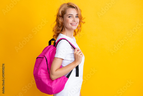 Excited redhead young woman student with backpack, isolated on yellow background studio Education in high school university college.