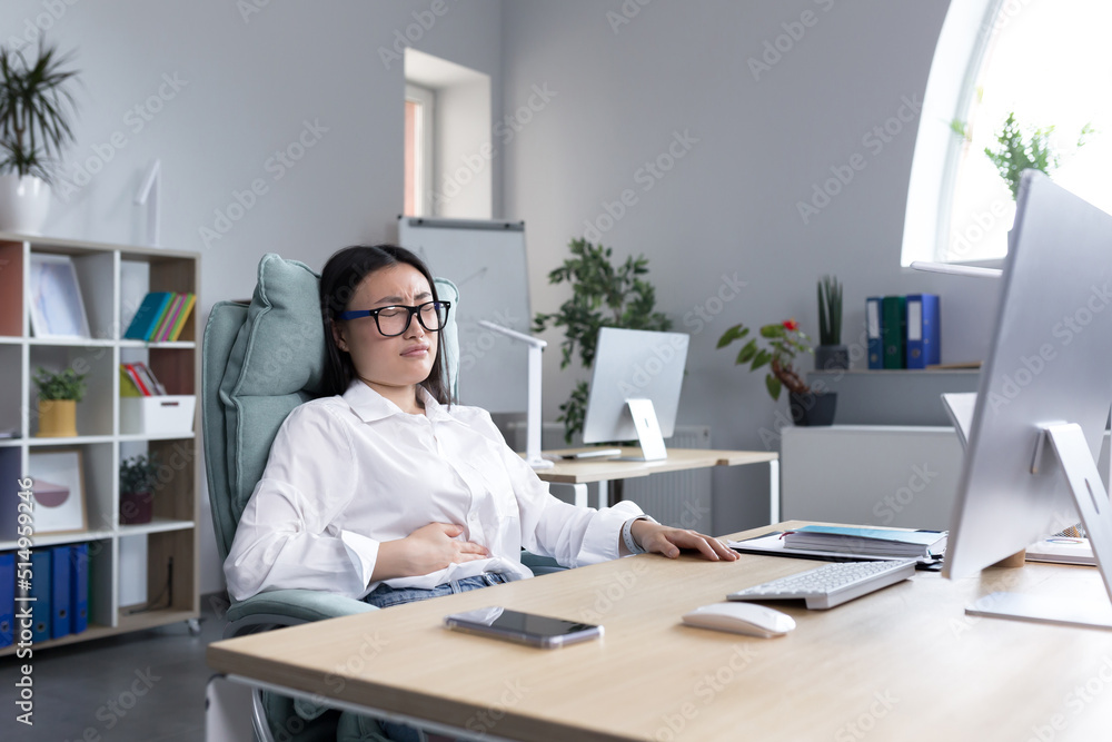 Asian business woman is sick in the office, has severe stomach pain, nausea and diarrhea. Asian business woman is sick in the office, has severe stomach pain, nausea and diarrhea.