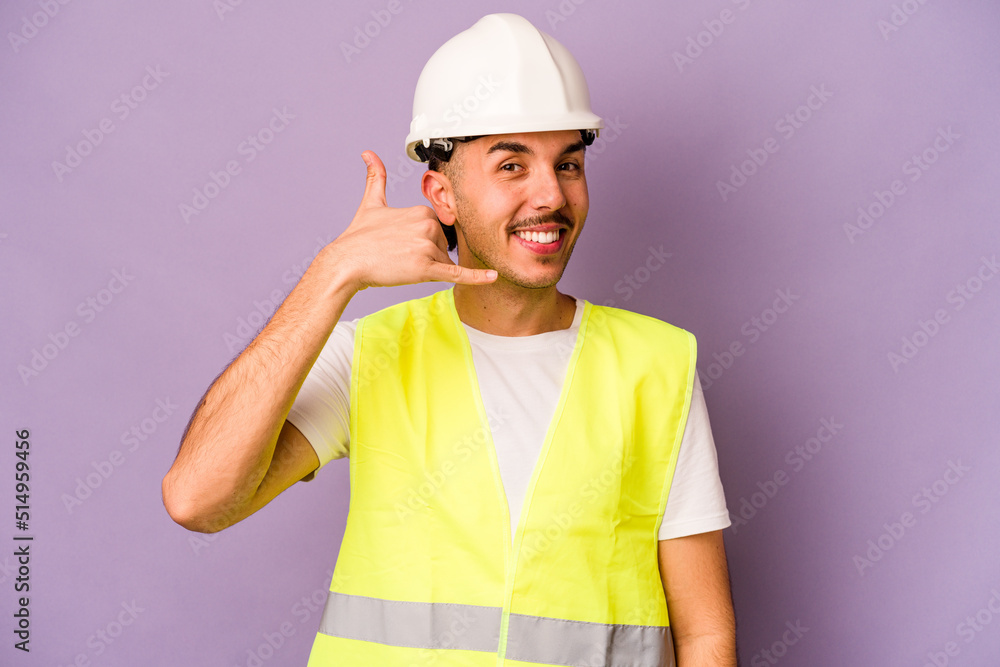 Young hispanic worker man isolated on purple background showing a mobile phone call gesture with fingers.