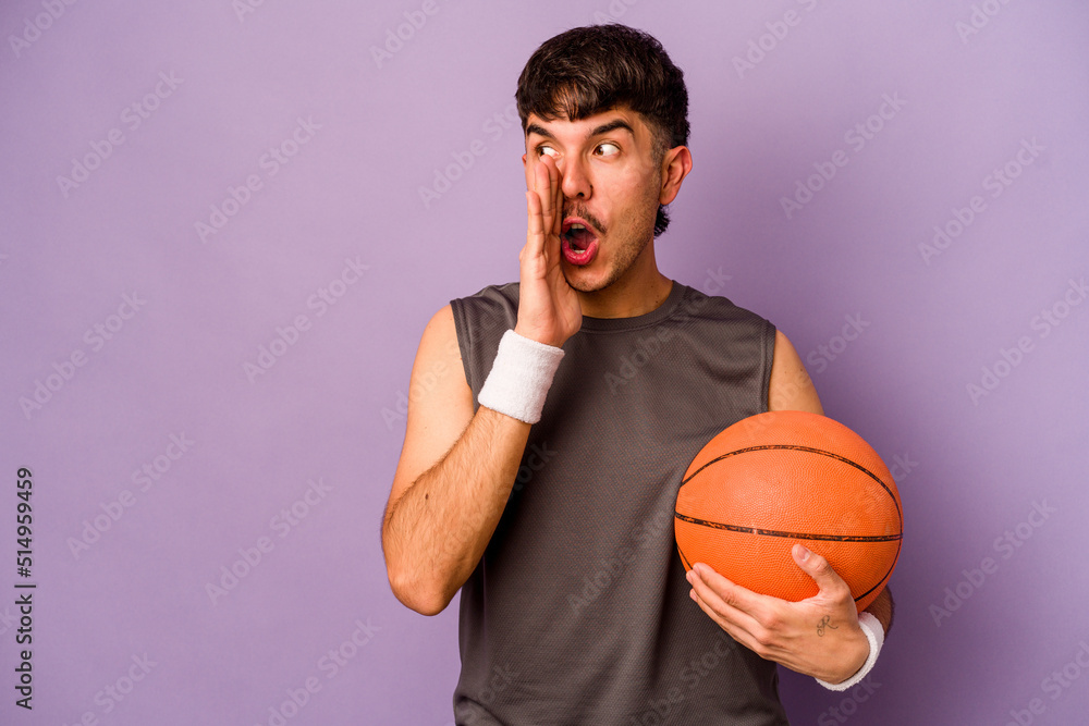 Young hispanic basketball player man isolated on purple background is saying a secret hot braking news and looking aside