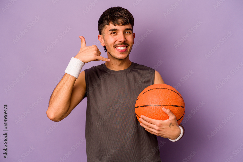 Young hispanic basketball player man isolated on purple background showing a mobile phone call gesture with fingers.