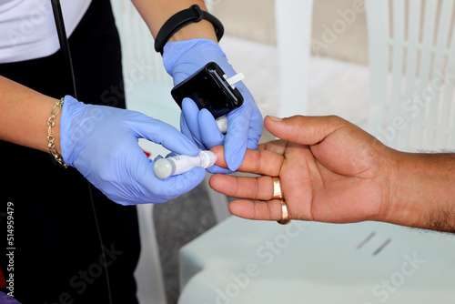 Doctor checking blood sugar level with glucometer. Treatment of diabetes concept.