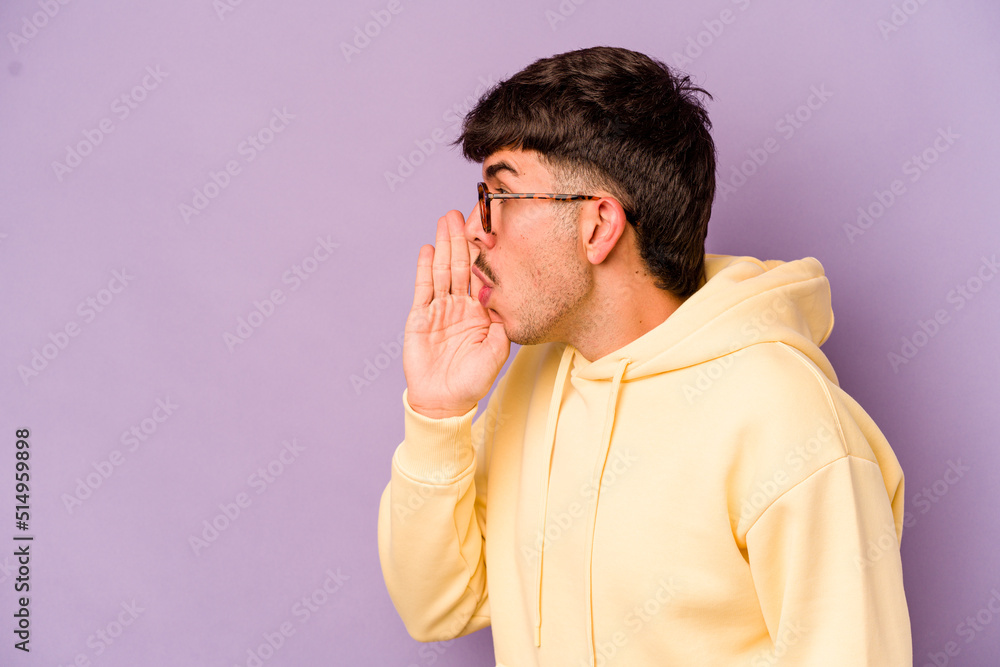 Young caucasian man isolated on purple background is saying a secret hot braking news and looking aside Young caucasian man isolated on purple background is saying a secret hot braking news and looking aside