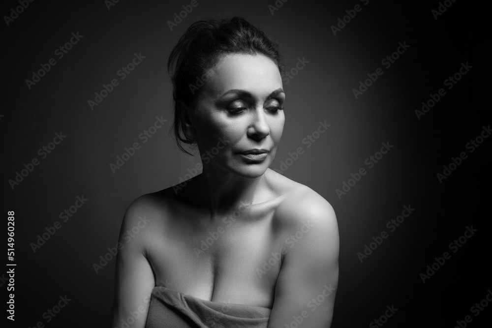 Portrait of a sensual fifty -year -old woman on grey studio background. Monochrome shot. Portrait of a sensual fifty -year -old woman on grey studio background. Monochrome shot.