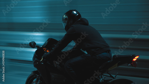 A man rides a sports motorcycle through the city at night