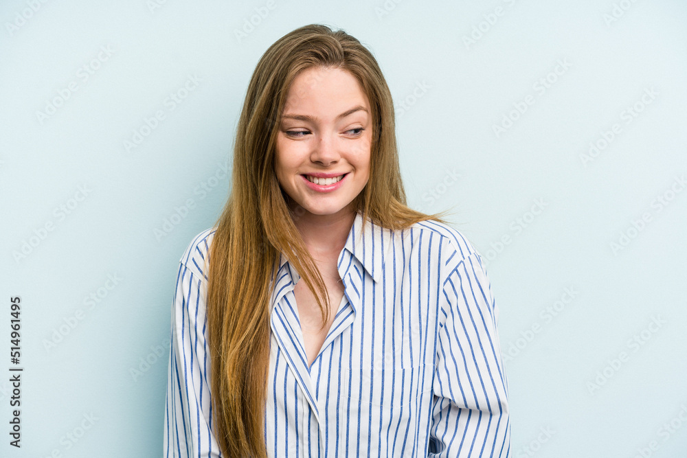 Young caucasian woman isolated on blue background laughs and closes eyes, feels relaxed and happy. Young caucasian woman isolated on blue background laughs and closes eyes, feels relaxed and happy.