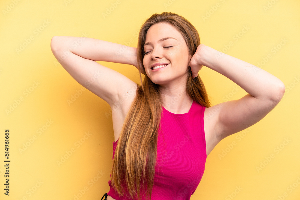 Young caucasian woman isolated on yellow background feeling confident, with hands behind the head. Young caucasian woman isolated on yellow background feeling confident, with hands behind the head.