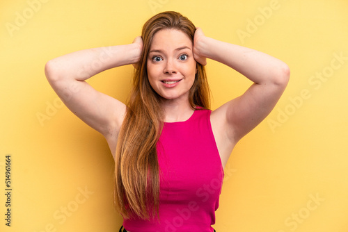 Young caucasian woman isolated on yellow background screaming with rage.