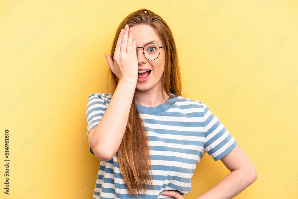 Young caucasian woman isolated on yellow background having fun covering half of face with palm. Young caucasian woman isolated on yellow background having fun covering half of face with palm.