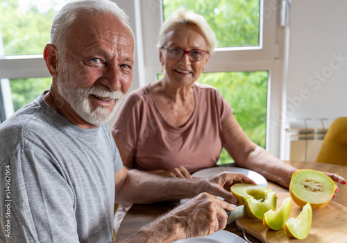 Senior couple eating melon at home