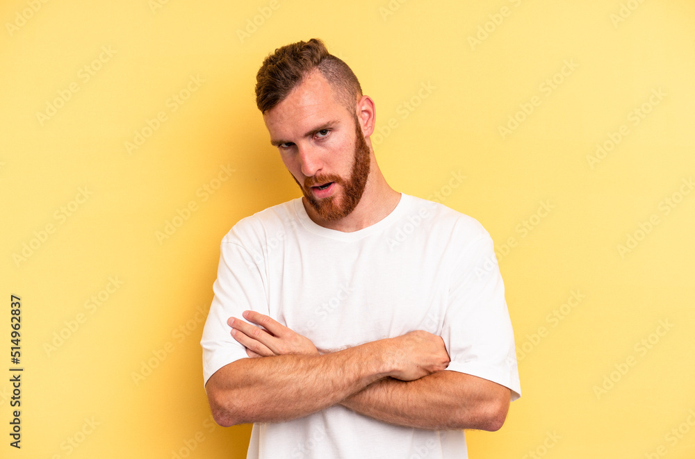 Young caucasian man isolated on yellow background who is bored, fatigued and need a relax day. Young caucasian man isolated on yellow background who is bored, fatigued and need a relax day.