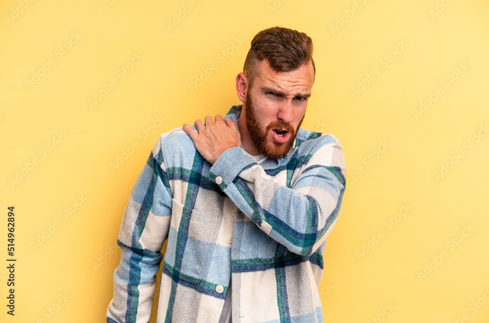 Fototapeta premium Young caucasian man isolated on yellow background having a shoulder pain.
