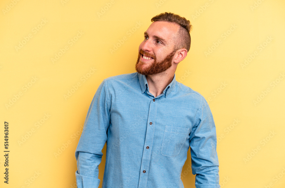 Young caucasian man isolated on yellow background relaxed and happy laughing, neck stretched showing teeth. Young caucasian man isolated on yellow background relaxed and happy laughing, neck stretched showing teeth.